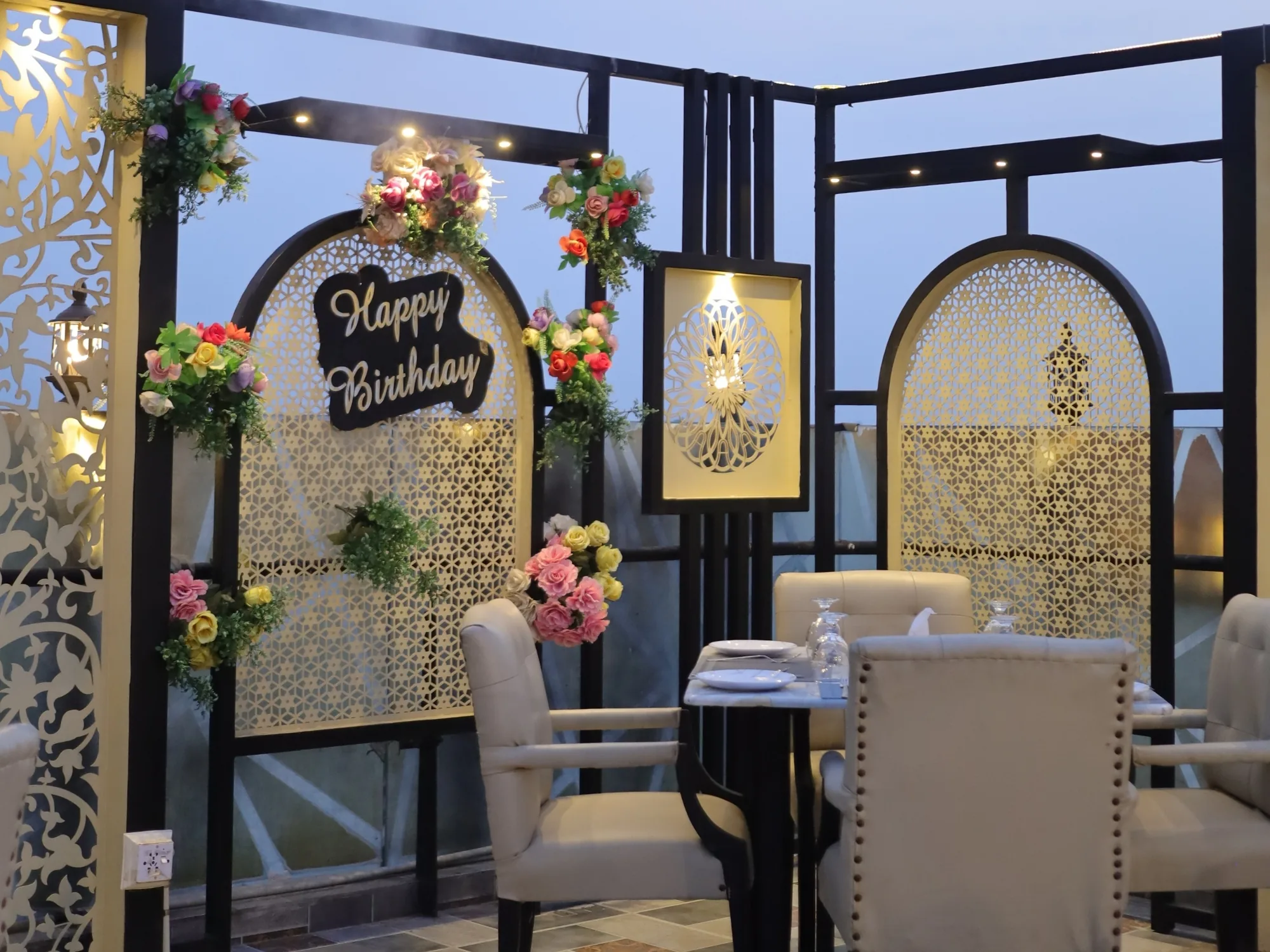 A table at Aangan decorated for a birthday, flowers on the screen behind it