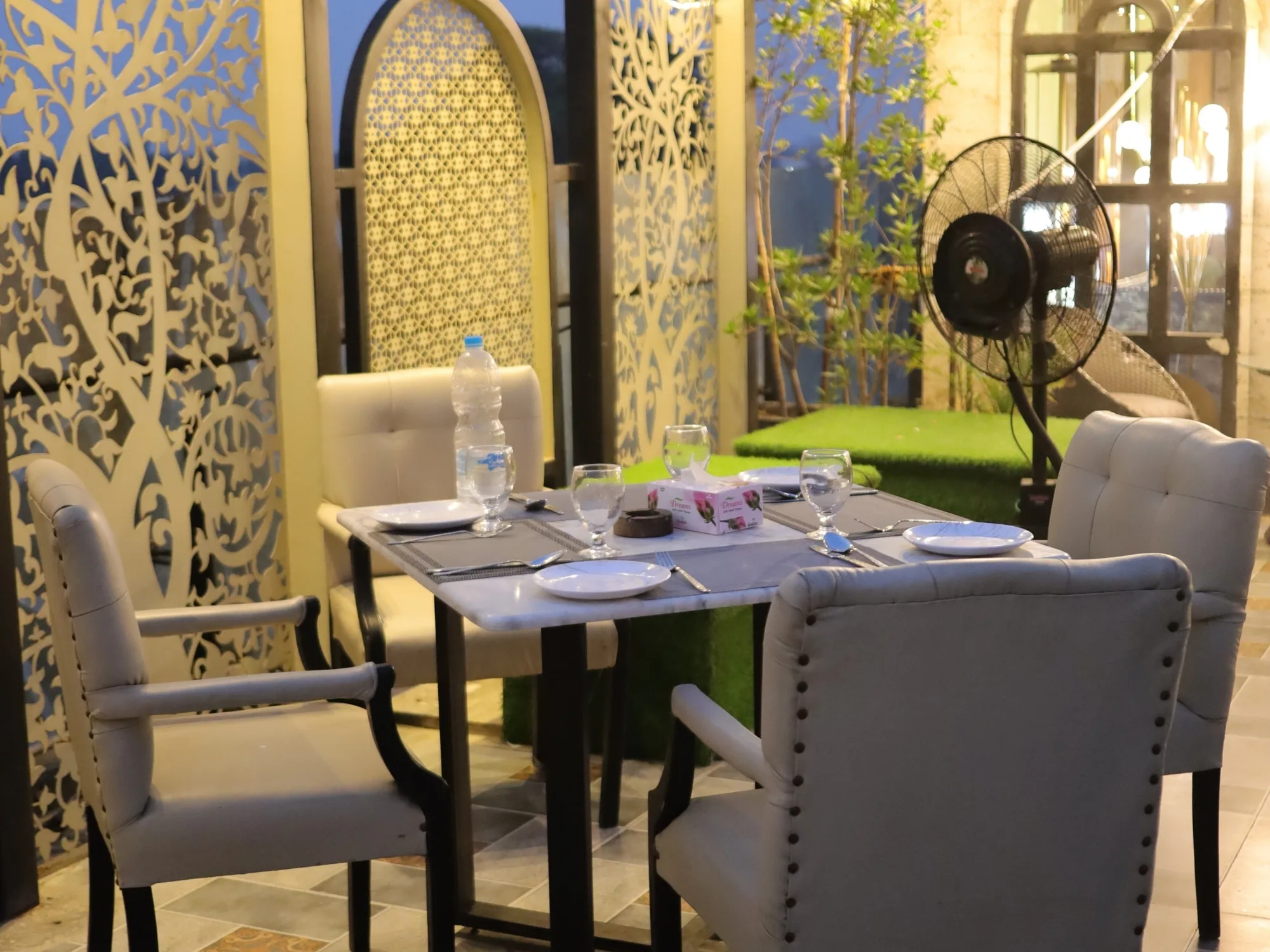 Dining at Aangan behind carved screens, the terrace planting alongside