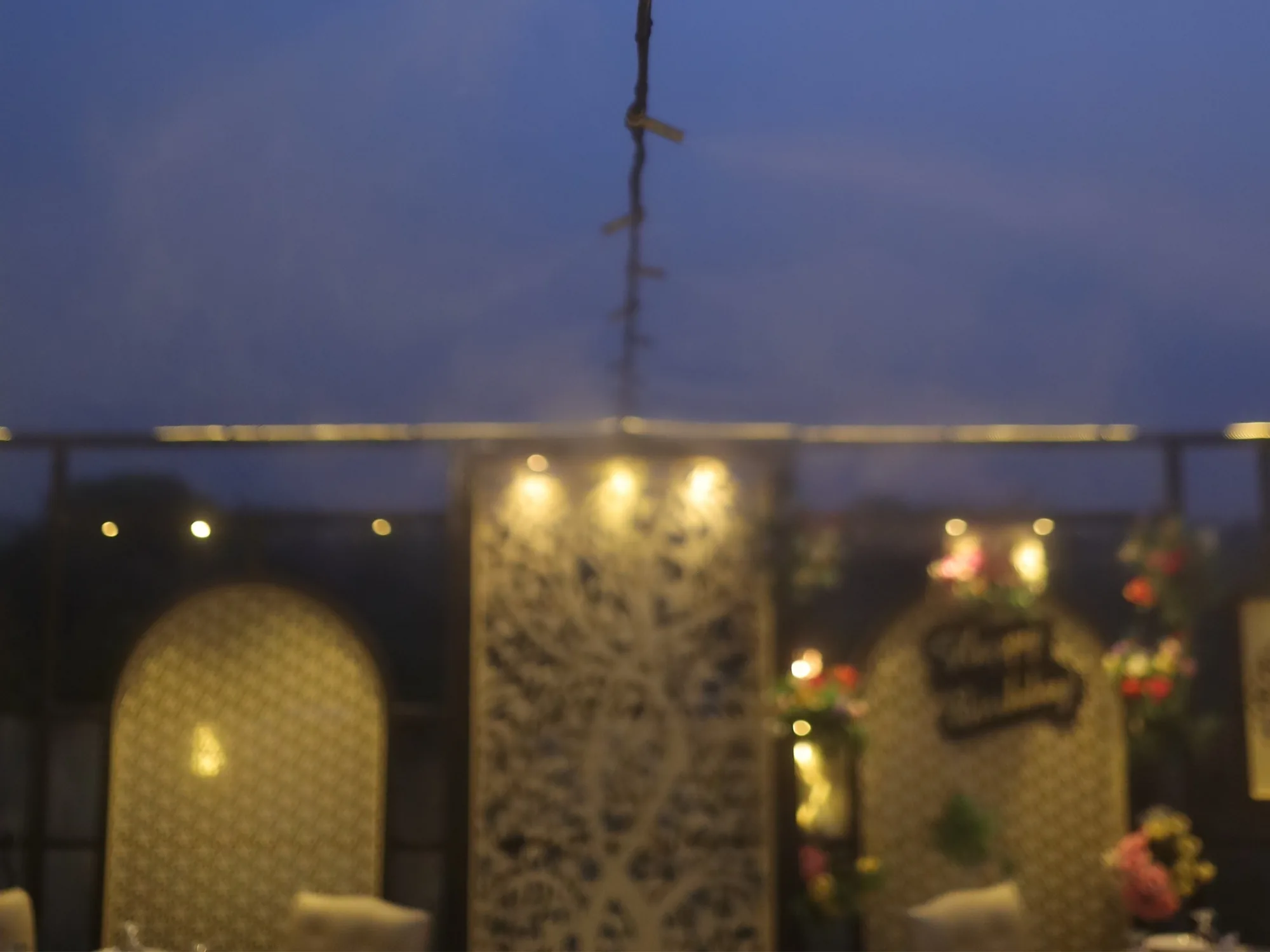 The Aangan rooftop at dusk, its carved screens lit along the terrace