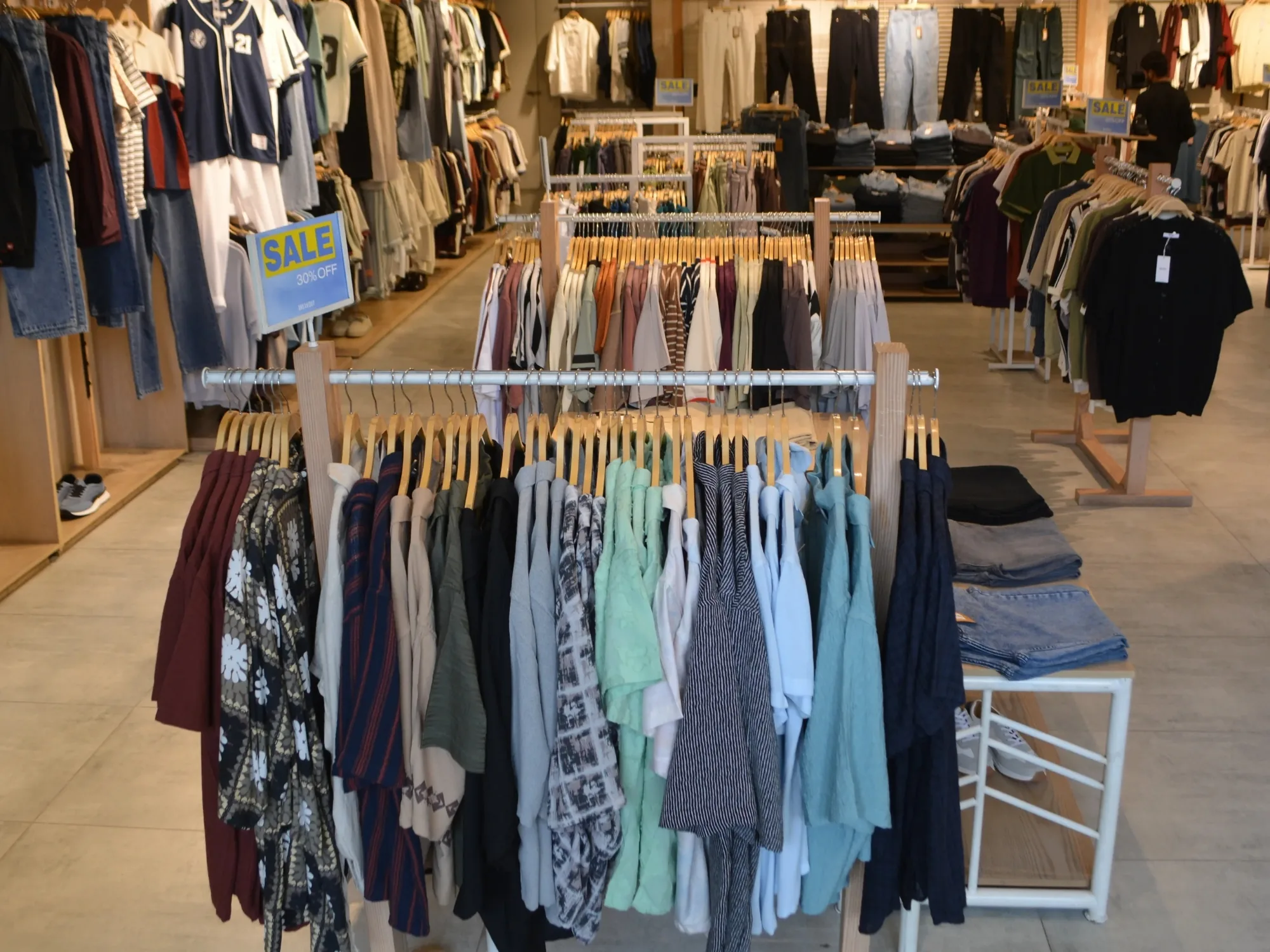 The BREAKOUT shop floor at Xin Mall, rails of shirts and knitwear under wooden fixtures