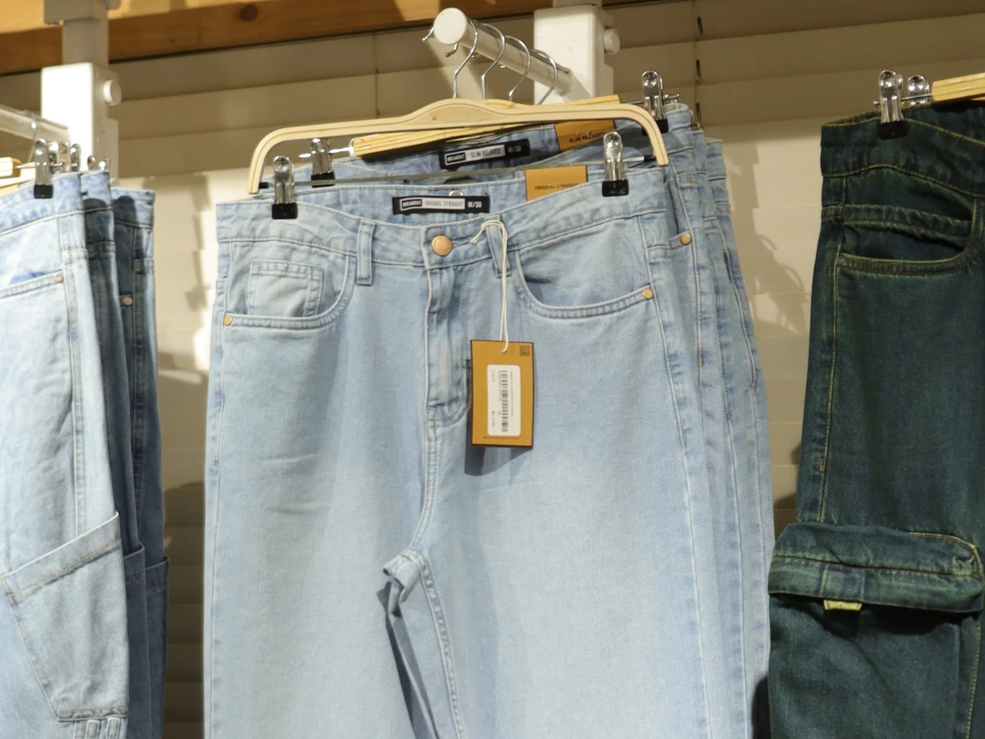 Light-wash denim on a rail at BREAKOUT, tagged and sized