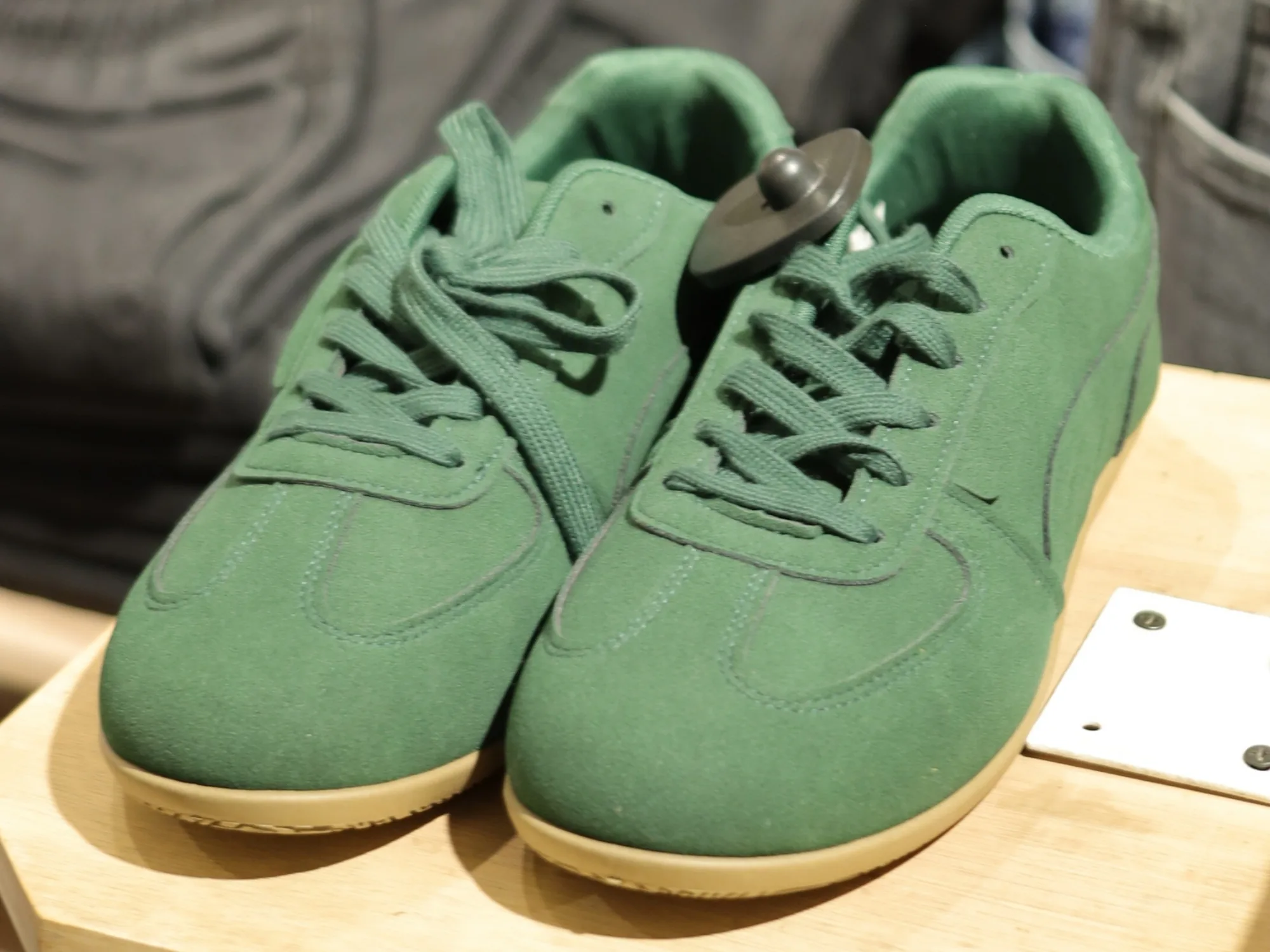 Green suede trainers on a display block at BREAKOUT