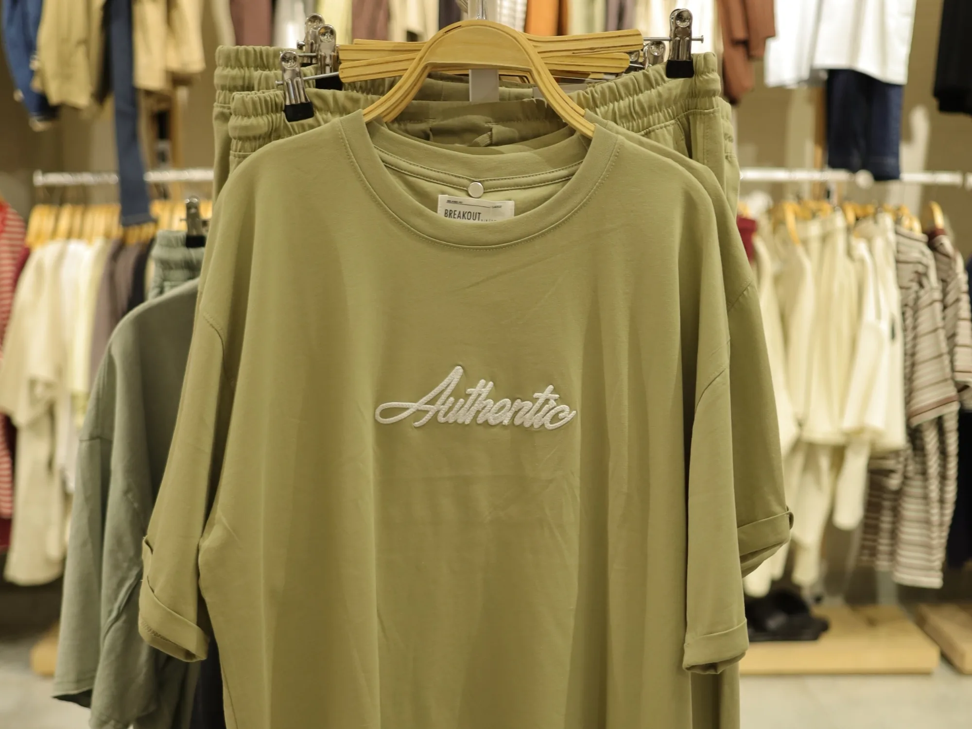 An olive printed sweatshirt on the BREAKOUT rail