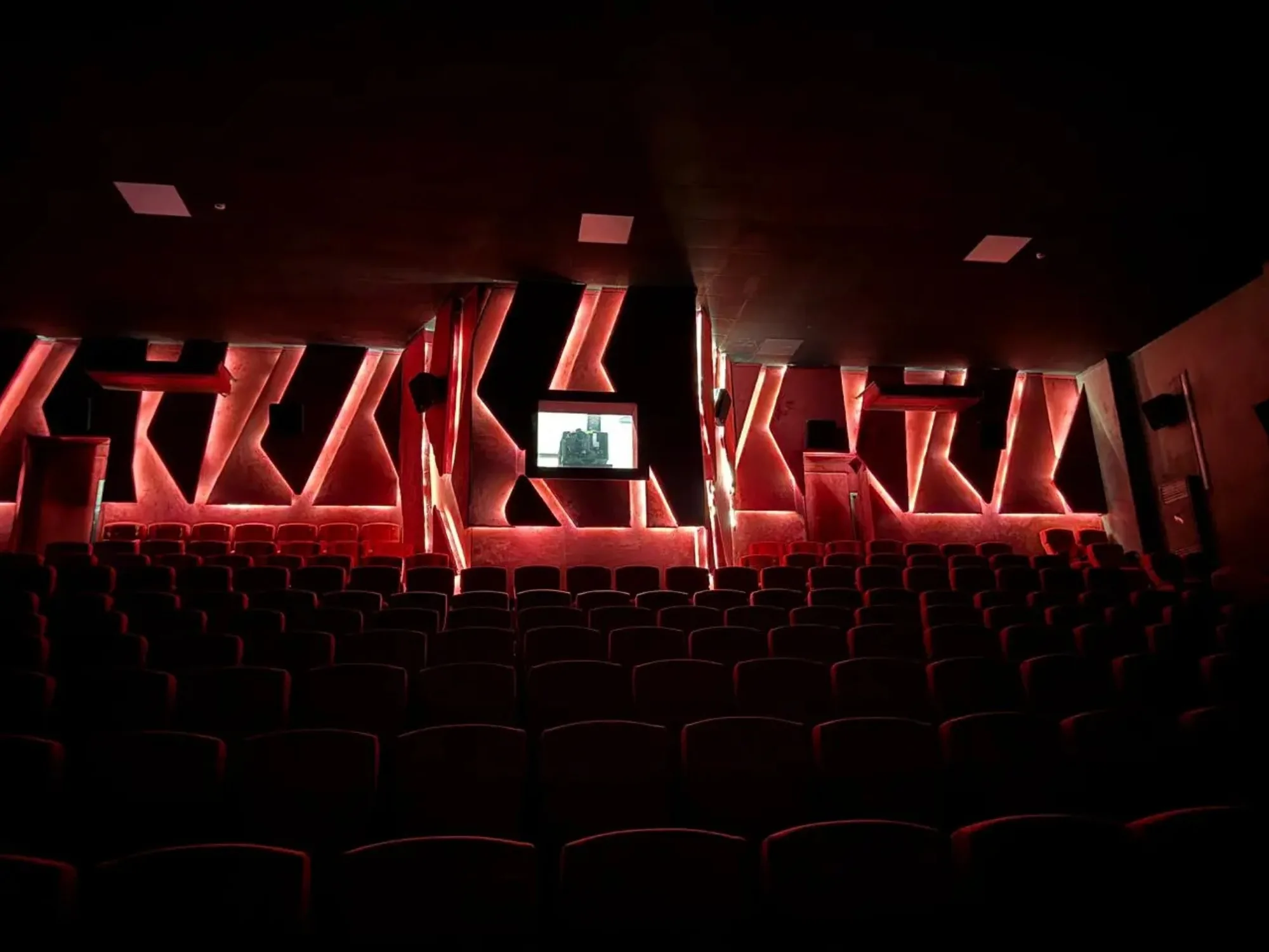 A CineStar auditorium in low light, the red seats picked out row by row