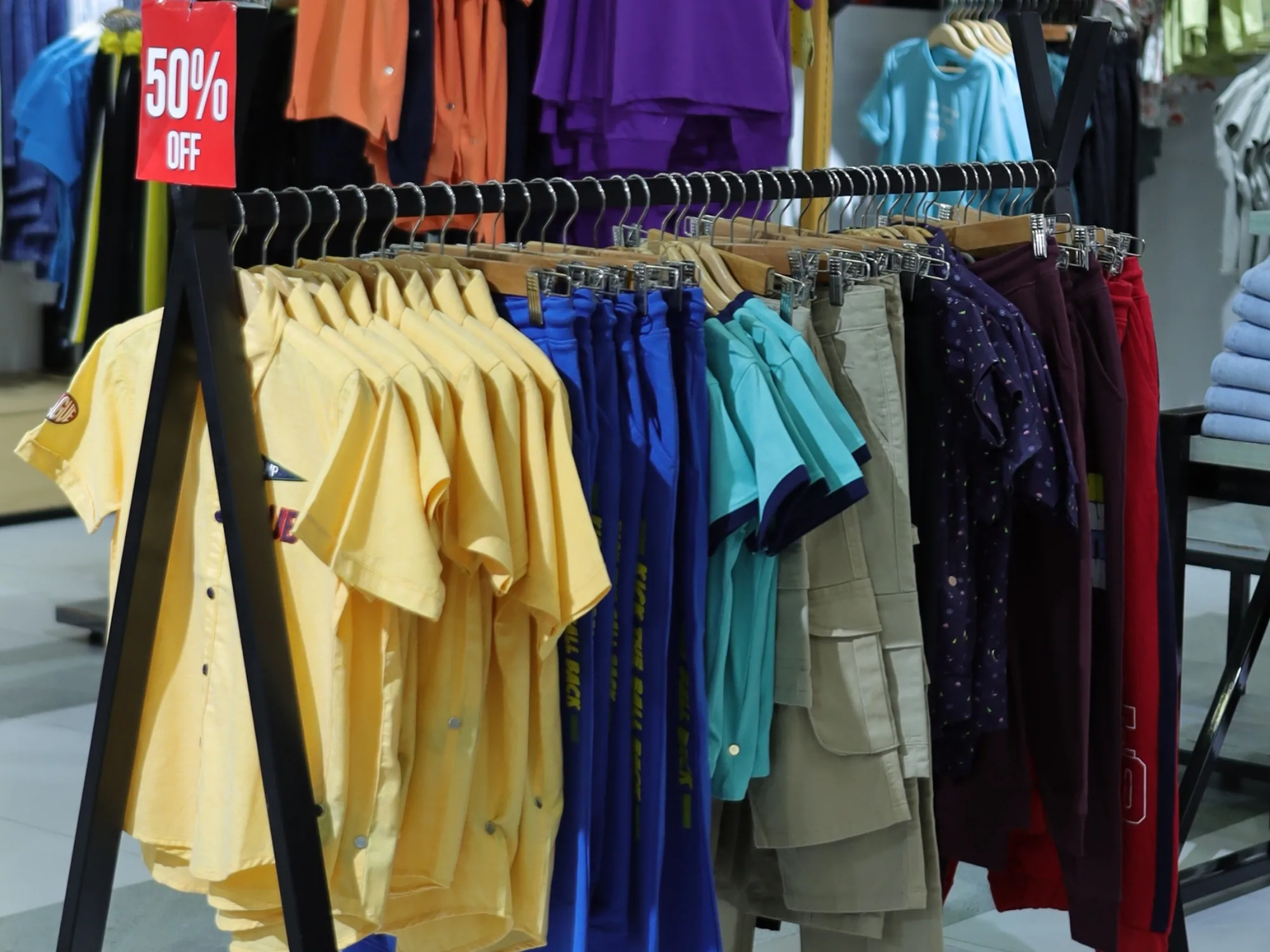 Summer shirts on an A-frame rail at ONE, marked fifty per cent off