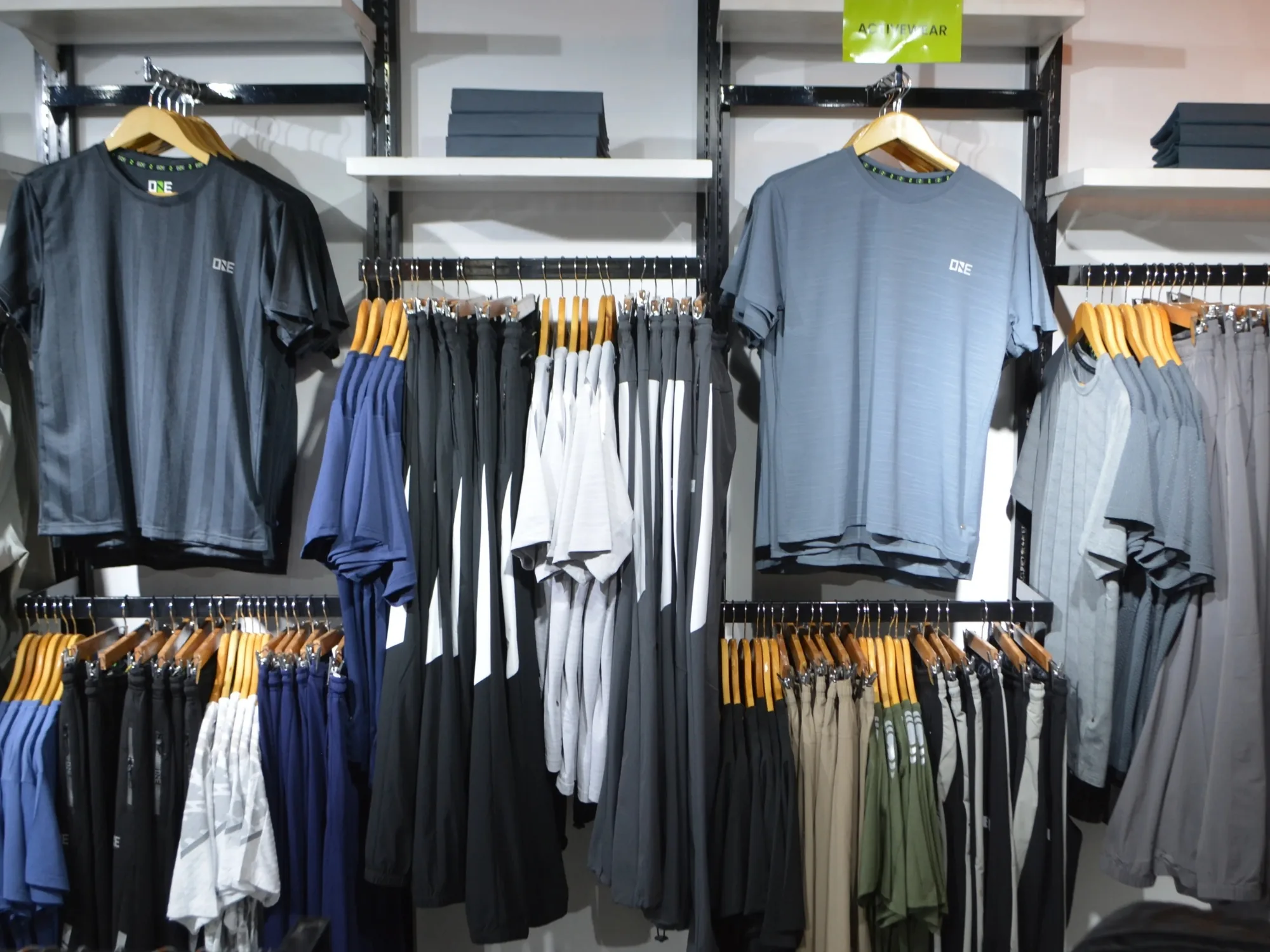 Menswear at ONE, tees and trousers on wooden hangers