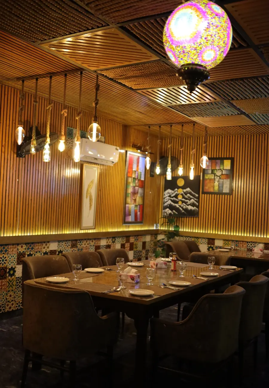 The warm-lit dining room at Aangan under hanging bulbs