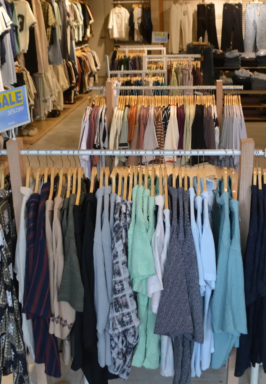 Rails of shirts on wooden hangers at BREAKOUT